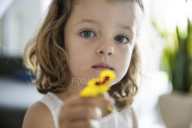 Little girl holding pansy blossom in her hand, close-up — Stock Photo