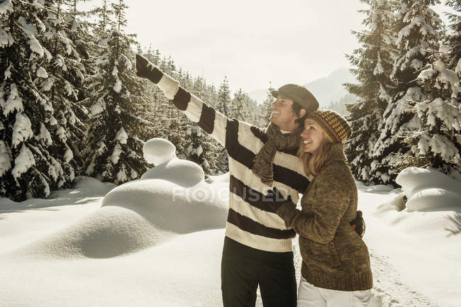 Casal sorridente apontando na paisagem de inverno em Salzburgo, Áustria — Fotografia de Stock