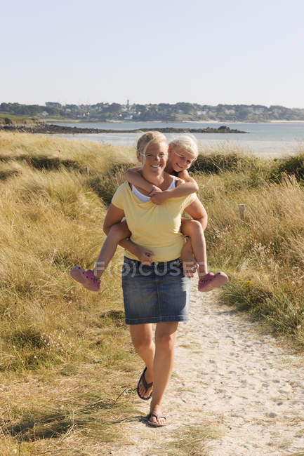 Mother and daughter walking on dune — Stock Photo