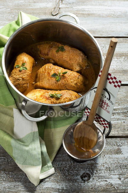 Involtini di maiale con tovagliolo e cucchiaio di legno sul tavolo di legno, da vicino — Foto stock