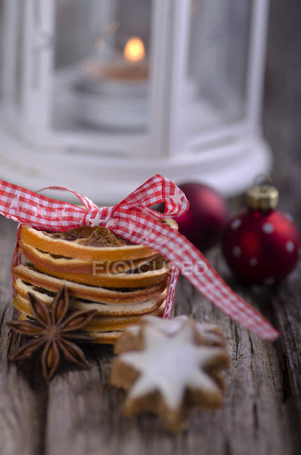 Anis estrelado e casca de laranja com bugigangas de Natal na mesa de madeira — Fotografia de Stock