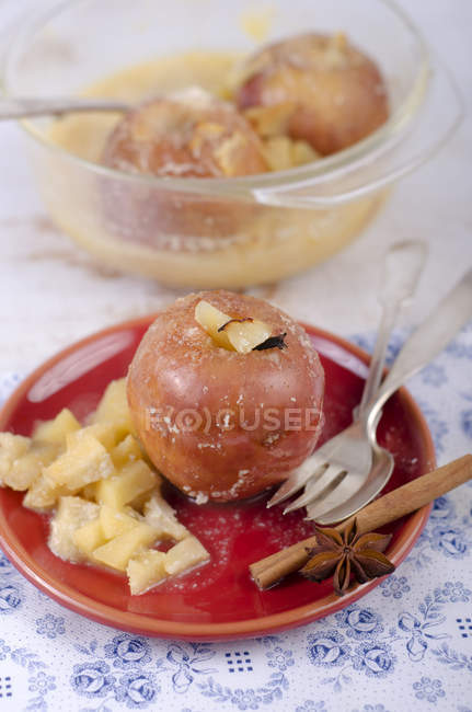 Baked apples with almonds and cinnamon on wooden table — Stock Photo