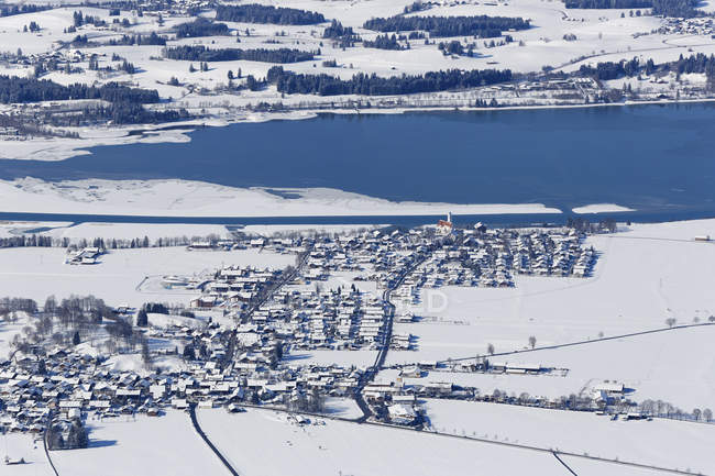 Germany, Bavaria, View of Lake Forggensee and small town — Stock Photo