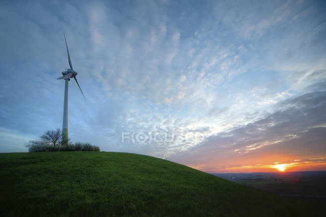 Alemania, Baden-Wuerttemberg, Korntal-Muenchingen, Gruener Heiner, molino de viento al atardecer - foto de stock