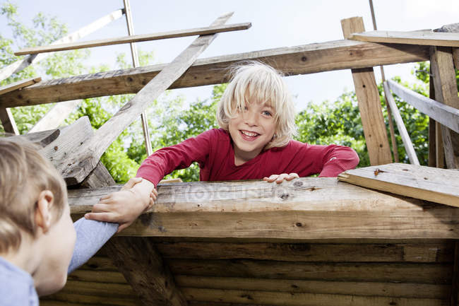 Garçons jouant dans l'aire de jeux à la maison en bois arbre — Photo de stock