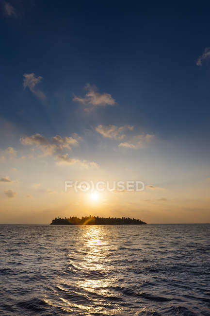 Maldivas, ilha ao pôr do sol sobre a água — Fotografia de Stock