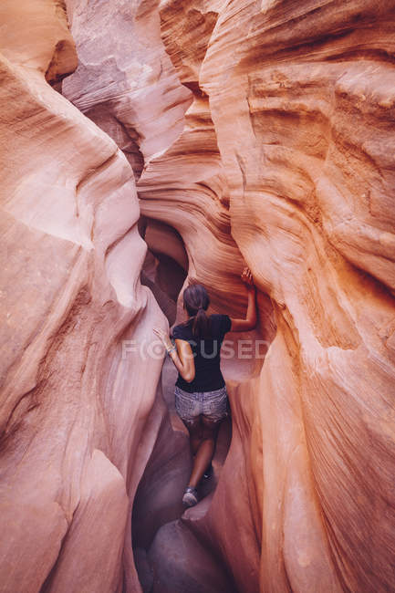 Usa, utah, escalante, peek-a-boo und gruselige Schlitzschluchten, junge Frau klettert in Schlucht — Stockfoto
