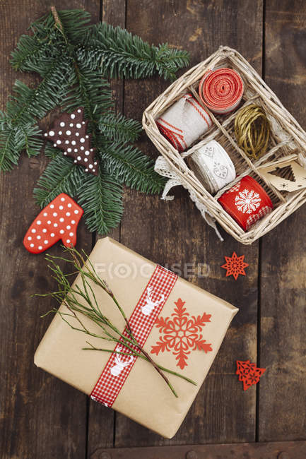 Regalo de Navidad y material de envoltura en mesa de madera - foto de stock