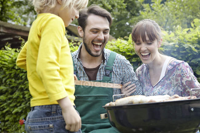 Famille ayant barbecue, souriant — Photo de stock