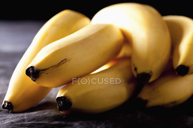 Racimo de plátanos frescos sobre tela negra - foto de stock