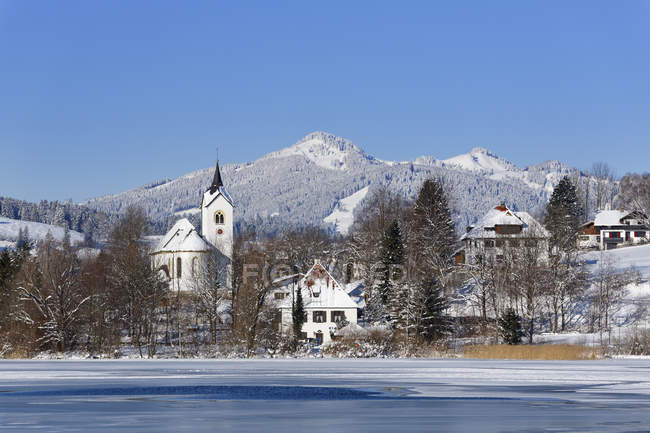 Германия, Бавария, вид на деревню Вайсензее и озеро возле Феттеля в дневное время — стоковое фото