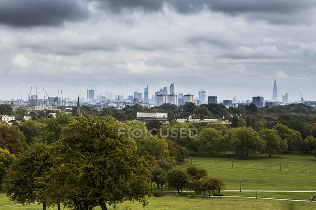 Reino Unido, Londres, Docklands, vista no horizonte da cidade, parque verde em primeiro plano — Fotografia de Stock