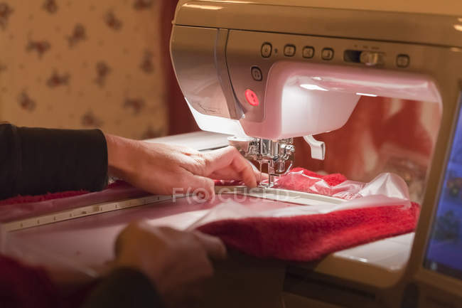 Mature woman embroidering with semi-professional embroidery machine — Stock Photo