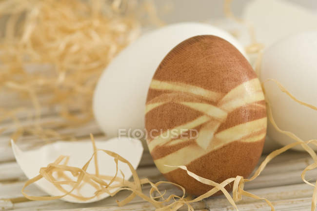 Раскрашенные пасхальные яйца на соломенном коврике — стоковое фото