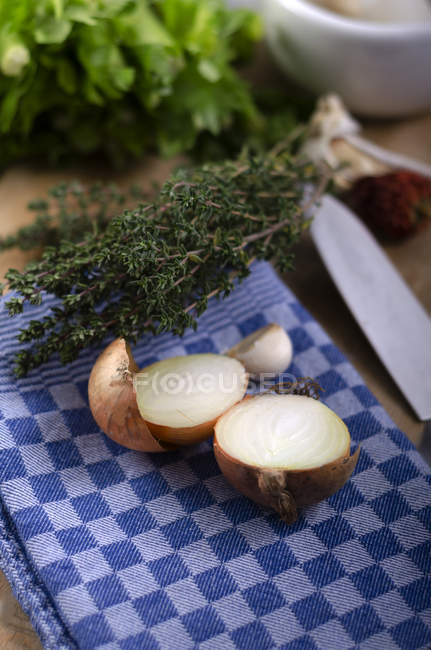 Oignon frais coupé en deux et thym sur le torchon — Photo de stock