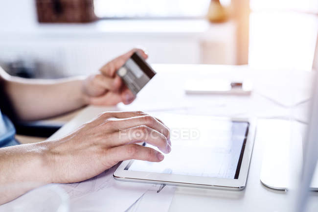 Hombre haciendo pago en línea con tarjeta de crédito - foto de stock