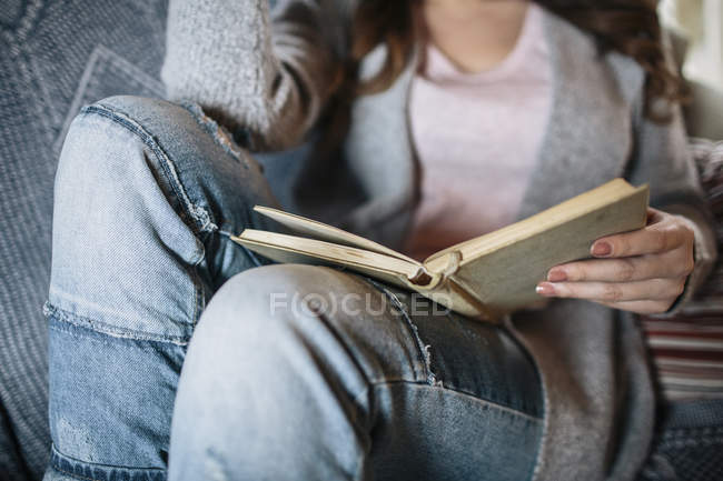 Jovem em casa lendo um livro — Fotografia de Stock