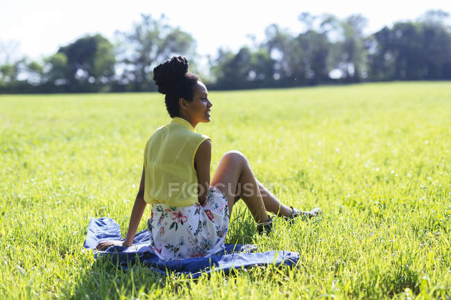 Jovem mulher relaxando em um prado — Fotografia de Stock