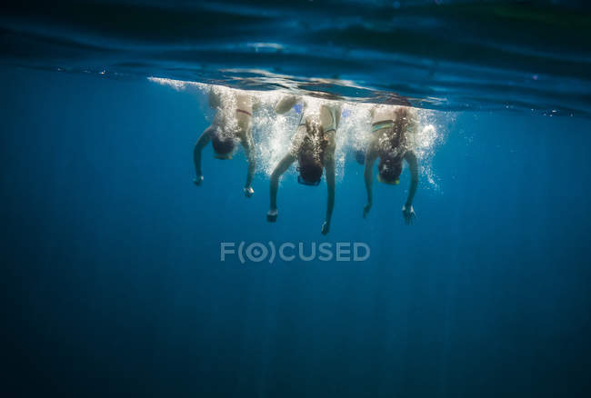Three girls swimming under water at daytime — Stock Photo