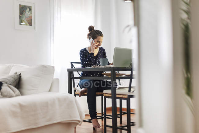 Junge Frau arbeitet zu Hause mit Laptop — Stockfoto