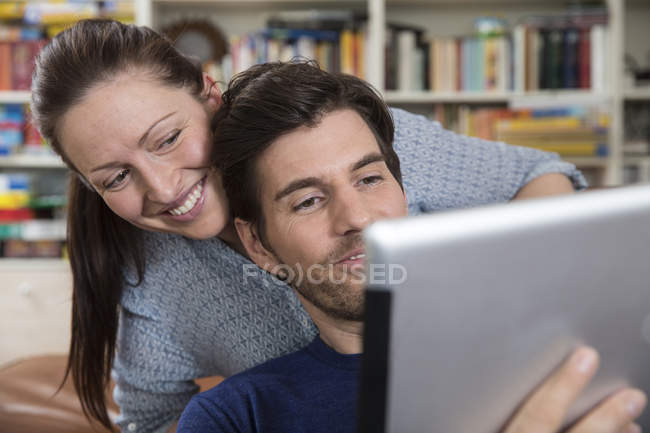 Erwachsenes Paar auf Sofa liegend, mit digitalem Tablet — Stockfoto