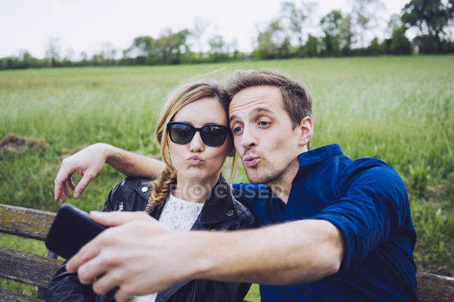 Porträt eines schmollenden Paares beim Selfie mit dem Smartphone — Stockfoto