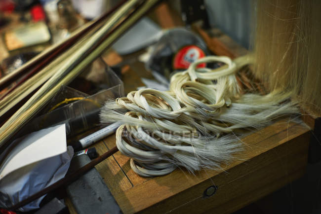 Tools and horsehair for the bows in a violin maker's workshop — Stock Photo