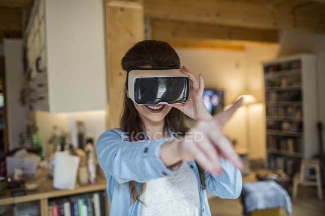 Молодая женщина дома в очках виртуальной реальности — стоковое фото