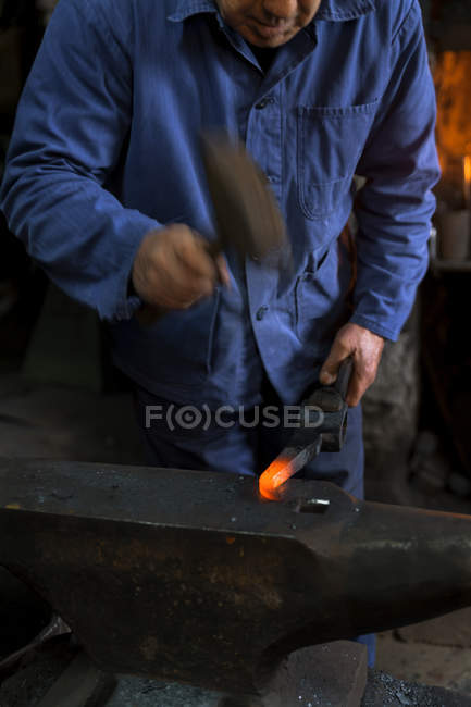 Blacksmith working on pickaroon at historic blacksmith's shop — Stock Photo