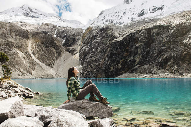 Peru, Huaraz, Huascaran National Park, woman relaxing after a trekking on lagoon — Stock Photo