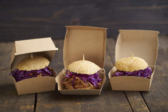 Mini-hamburguesa con cerdo tirado, col roja y cebolla frita en cajas - foto de stock