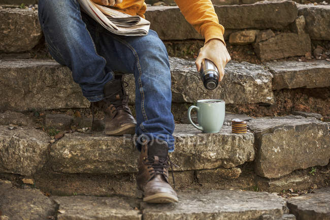 Jovem sentado em passos tendo coffee break, vista parcial — Fotografia de Stock