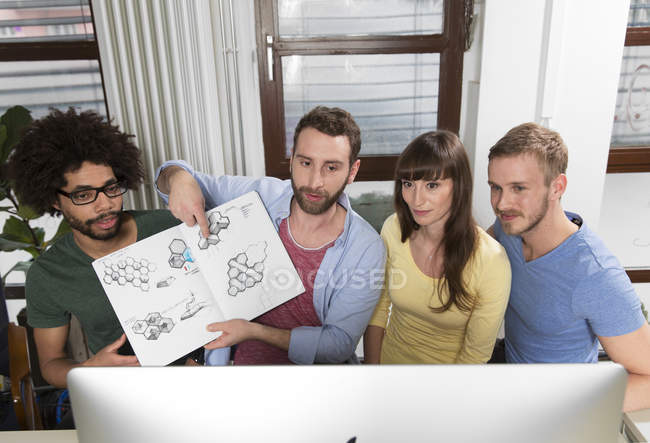Equipe de profissionais criativos participando de uma videoconferência e mostrando rascunhos — Fotografia de Stock