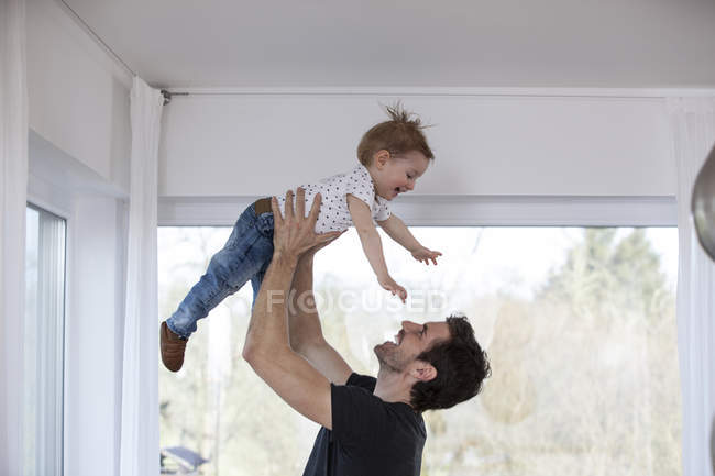 Happy father lifting laughing son — Stock Photo