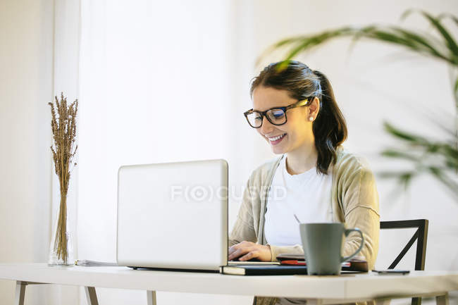 Женщина работает с ноутбуком в современном домашнем офисе — стоковое фото