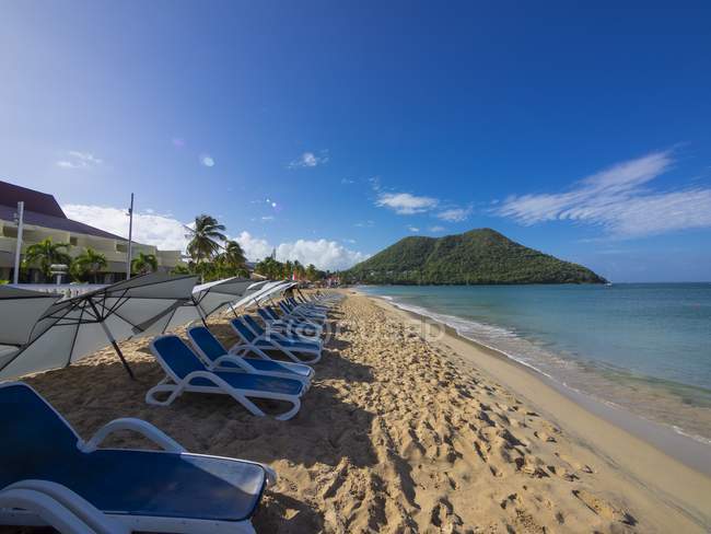 Caribe, Antillas Menores, Santa Lucía, Bahía de Rodney, tumbonas vacías en la playa - foto de stock