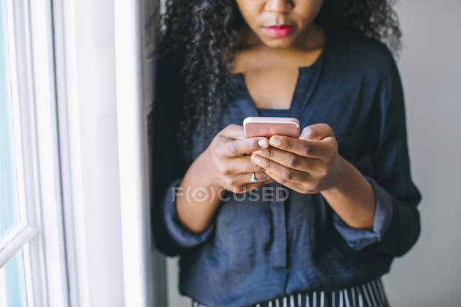 Primer plano de la mujer joven utilizando el teléfono inteligente - foto de stock