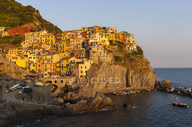 Italia, Liguria, Cinque Terre, Manarola y vista de casas en la orilla durante el día - foto de stock