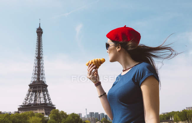 France, Paris, femme tenant croissantregardant la Tour Eiffel — Photo de stock