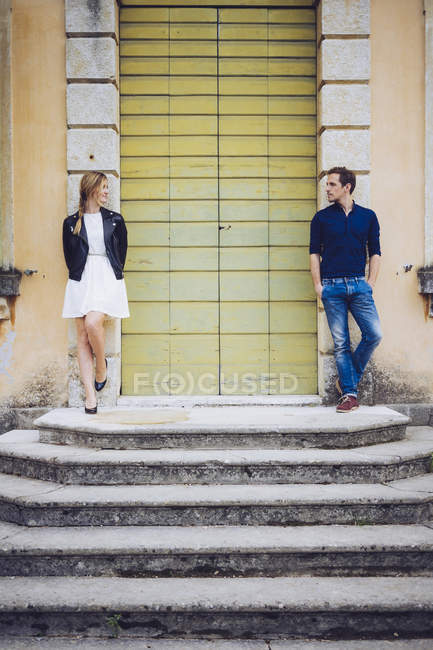 Італія, Верона, пара стоячи Крім дерев'яні двері дивляться один на одного — стокове фото