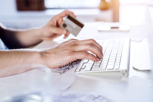 Hombre haciendo pago en línea con tarjeta de crédito - foto de stock