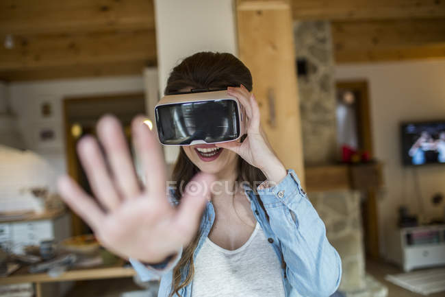 Jovem mulher em casa usando óculos de realidade virtual — Fotografia de Stock