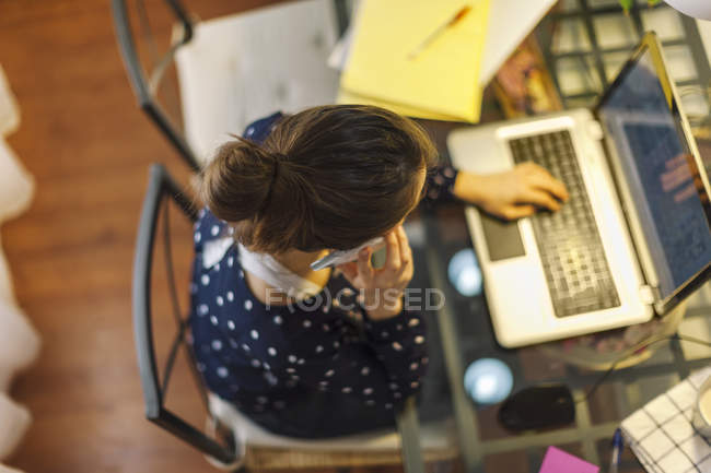 Giovane donna che lavora con il computer portatile a casa — Foto stock