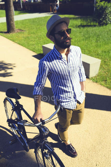 Чоловік з велосипедом, що йде пішки — стокове фото