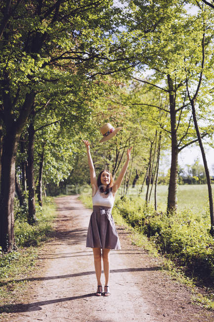 Щасливі молода жінка кидає її Літня капелюшок в повітря — стокове фото