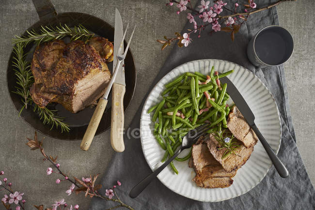 Jambe d'agneau au romarin, haricots verts et bacon sur assiette — Photo de stock