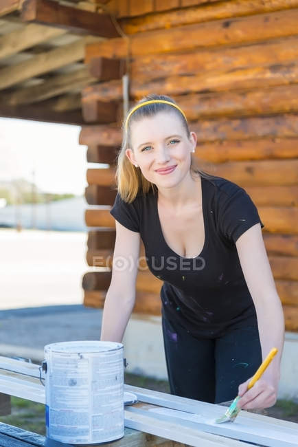 Sorrindo jovem mulher pintando bares — Fotografia de Stock