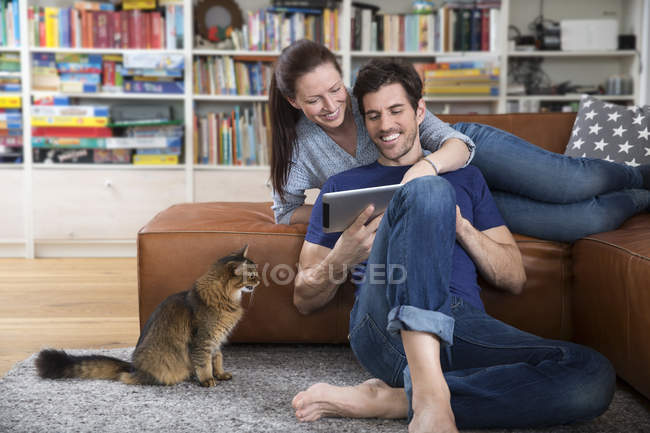 Erwachsenes Paar auf Sofa liegend, mit digitalem Tablet — Stockfoto