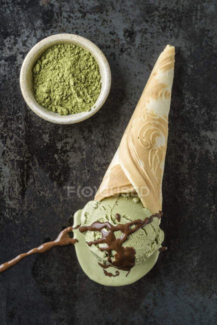 Helado de té verde con salsa de chocolate en cono de helado casero - foto de stock