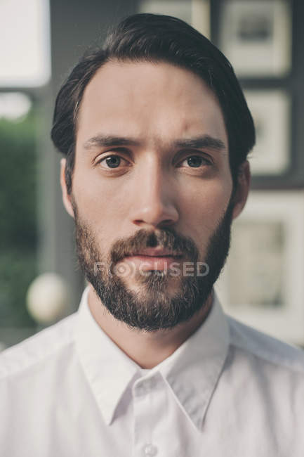 Портрет молодого бородатого мужчины в белой рубашке — стоковое фото